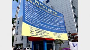 난민들의 평화적 대응: 9개의 NGO가 서명한 탄원서가 적힌 현수막