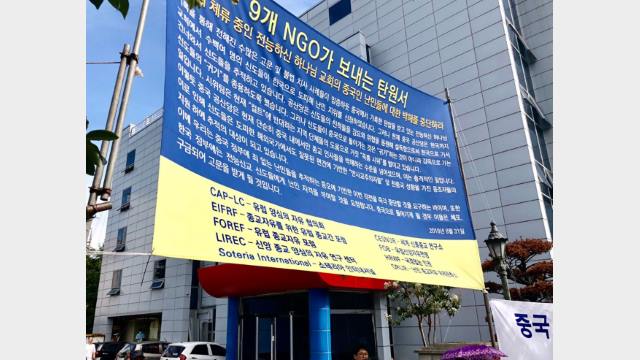 난민들의 평화적 대응: 9개의 NGO가 서명한 탄원서가 적힌 현수막