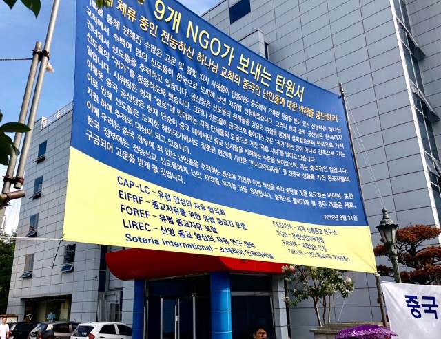 난민들의 평화적 대응: 9개의 NGO가 서명한 탄원서가 적힌 현수막