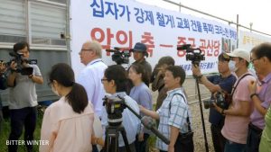조어러가 시위대와 기자들에게 둘러싸여 있다