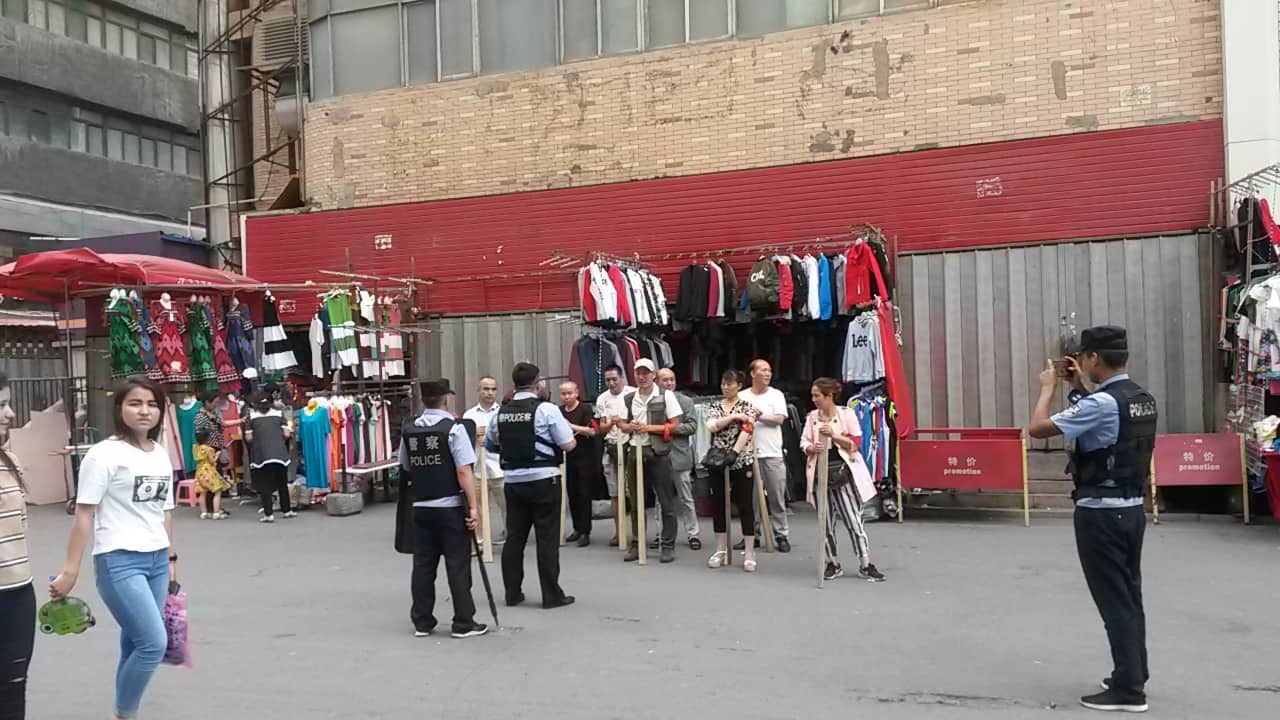 우루무치의 뒷골목 노점상들이 ‘무기’ 훈련을 마친 뒤, 지역 경찰이 이들의 사진을 찍고 있다. 2018년 8월