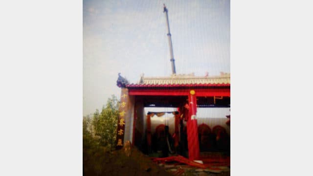 불당이 철거되는 현장, 크레인이 불상을 들어올리고 있다