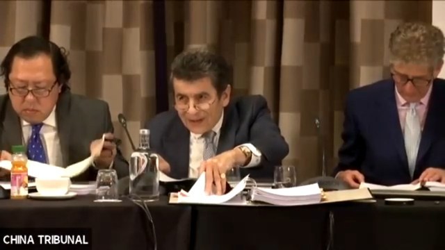 제프리 나이스 경(Sir Geoffrey Nice QC)이 주최한 재판, 오른편에는 말레이시아 변호사이자 국제 인권 운동가인 앤드류 쿠(Andrew Khoo)가 왼편에는 인권 문제에 특별히 관심을 갖고 있는 기업가 니컬러스 베치(Nicholas VEtch)가 자리했다