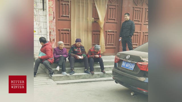 노신자가 폐쇄된 교회 문 앞에서 흐느끼며 기도를 하고 있다