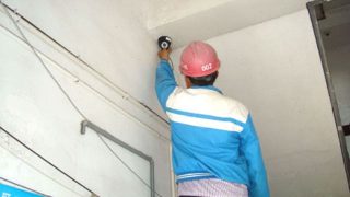 작업자가 감시 카메라를 설치하고 있다