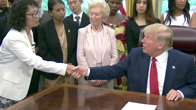 트럼프(Trump) 대통령이 고문 생존자인 장 위화(張玉華) 파룬궁 수련생과 악수를 하고 있다