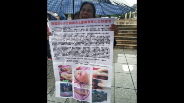 사람들에게 죽은 소년들의 사진을 보여 주고 있는 고인의 가족들