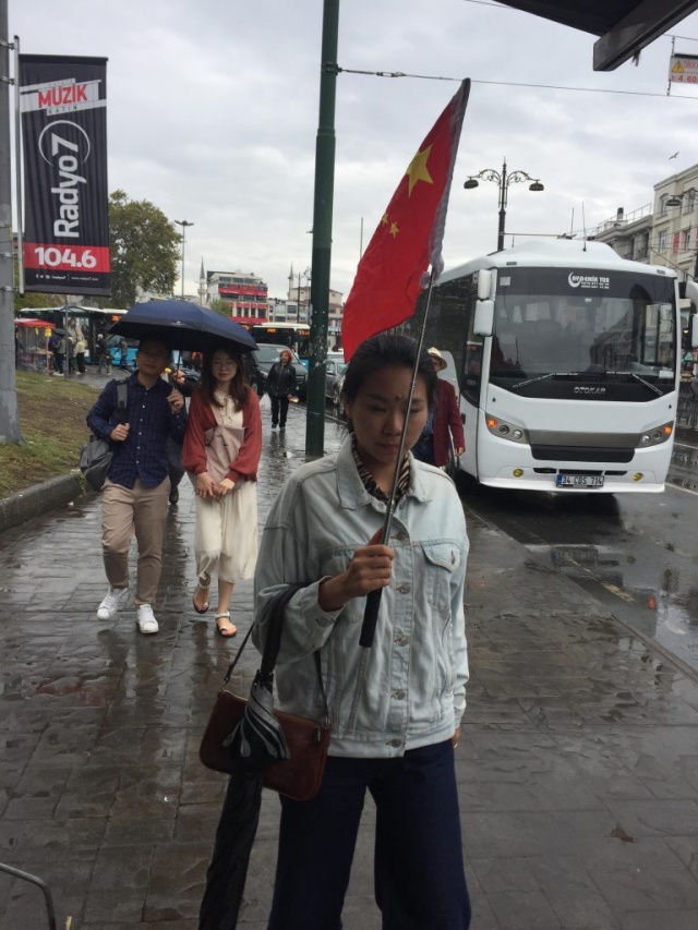 어느 관광 가이드가 오성홍기를 든 채 관광객들을 이끌고 이스탄불 거리에 있는 오래된 재래시장들을 지나는 모습