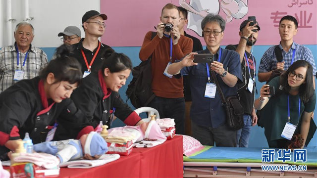 중국 및 외국 언론사 기자들이 신장 모위(墨玉)현의 재교육수용소 재소자들을 인터뷰하고 있는 모습