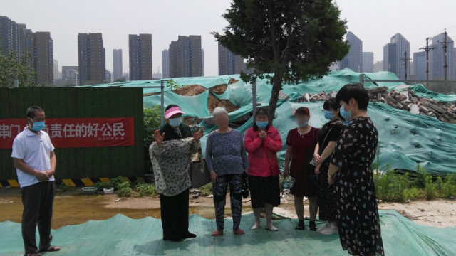 폐허로 변한 교회 옆에서 기도하고 있는 신자들